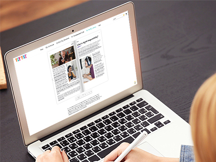 A woman sitting at a desk, focused on her laptop.